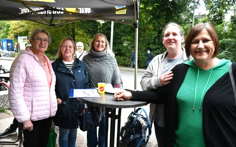 Mitarbeiterinnen und Kunden an einem Tisch in Rahm – demnächst muss der Austausch in Angermund erfolgen. Foto: sam