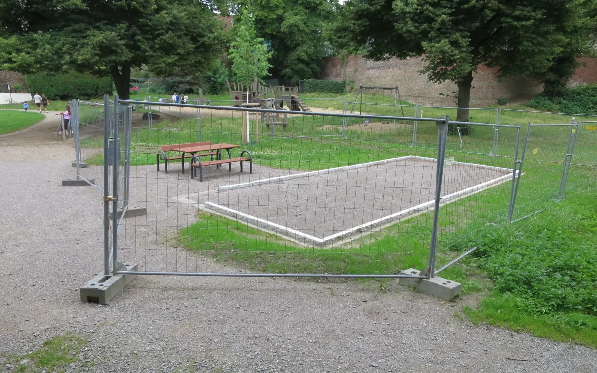 Noch ist der neue Bouleplatz in Kaiserswerth von einem Bauzaun umgeben. Eine Freigabe erfolgt erst, wenn der Rasen angewachsen ist. Foto: hs