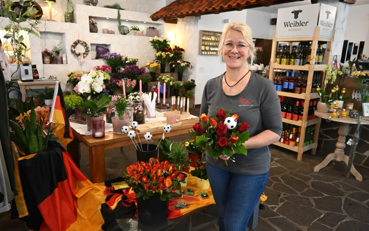 Kerstin Ruland und ihr Team kreieren duftende Rosensträuße in den Deutschlandfarben mit Fußballdeko – ein perfektes Mitbringsel. Foto: sam