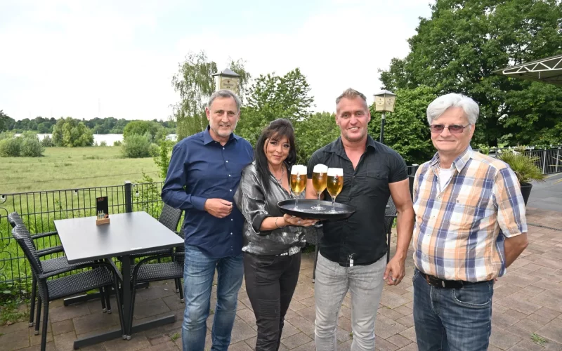 Anja und Andreas Klomfass (Mitte) servieren gerne Getränke im Biergarten – mit Blick auf den Rhein. Unterstützung für die erweiterte Konzession erhielten sie von Alfred Staiber und Wolfgang Schwertner (links). Foto: sam