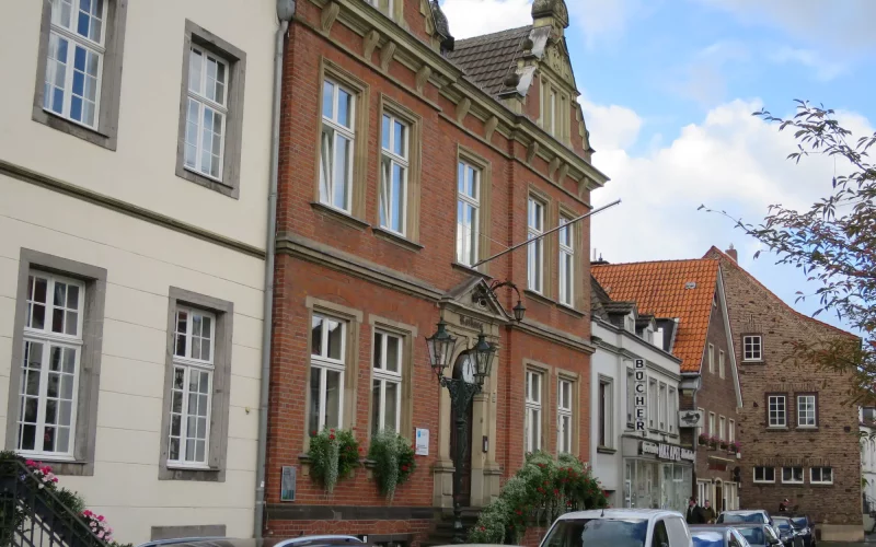 Wie auf dem gesamten Kaiserswerther Markt stehen Pkw, meist Stoßstange an Stoßstange, auch vor der blumengeschmückten Rathaustreppe. Foto: hs