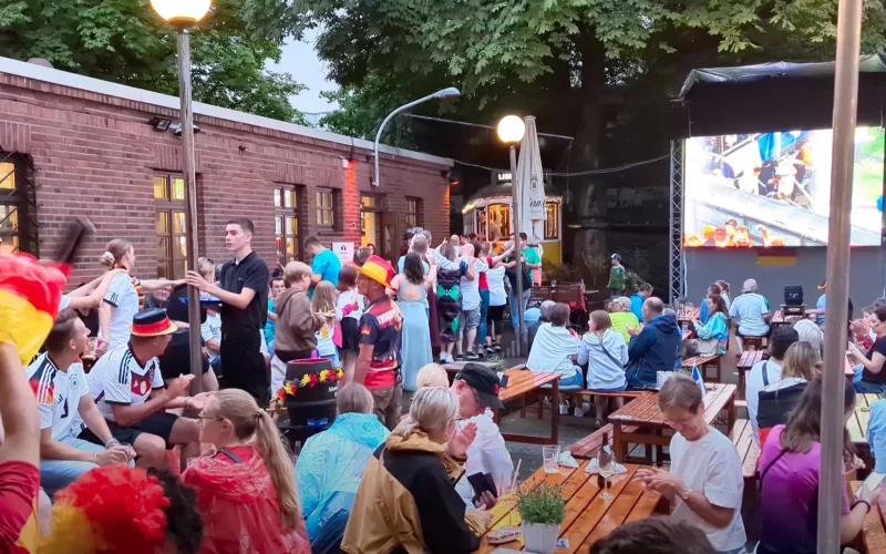 Polonaise während des Unwetters: Fans beim Rudelgucken in der Schlossallee feiern mit einem Hochzeitspaar während Deutschlands EM-Sieg. Foto: ah